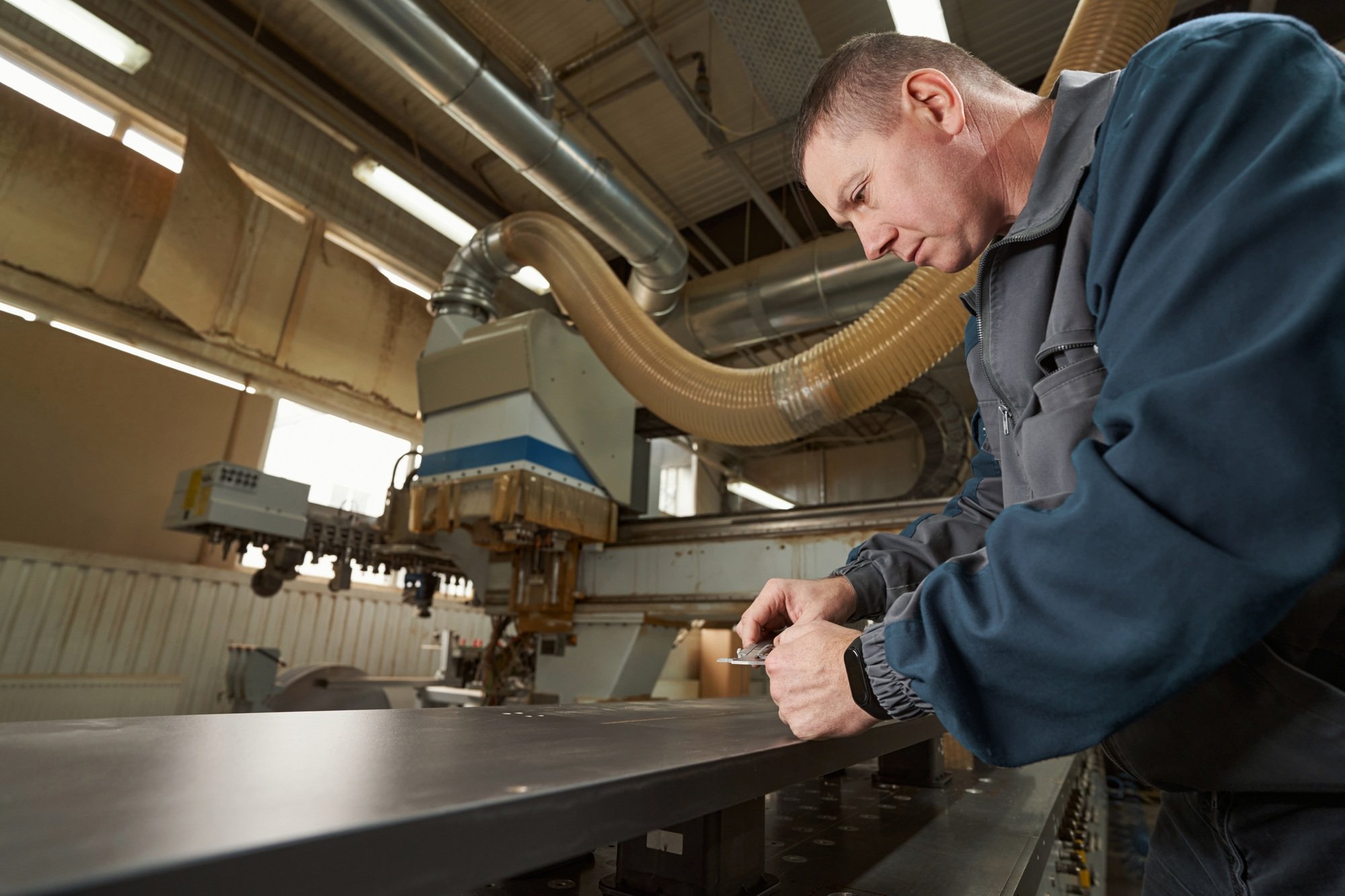 Attentive male person working in timber shop