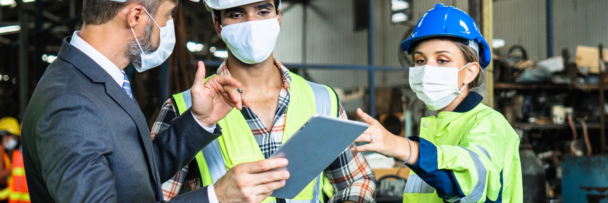 Industrial engineers and businessman in suite and safety helmet wearing mask working in factory